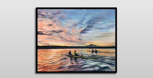 A framed painting on a white wall.

It is a colorful acrylic painting of two 2-man rowing shells on Lake Washington in Seattle. The sunrise illuminates the scene with bright yellows, oranges, and purples. A floating bridge and Mount Rainier are seen off to the distance.