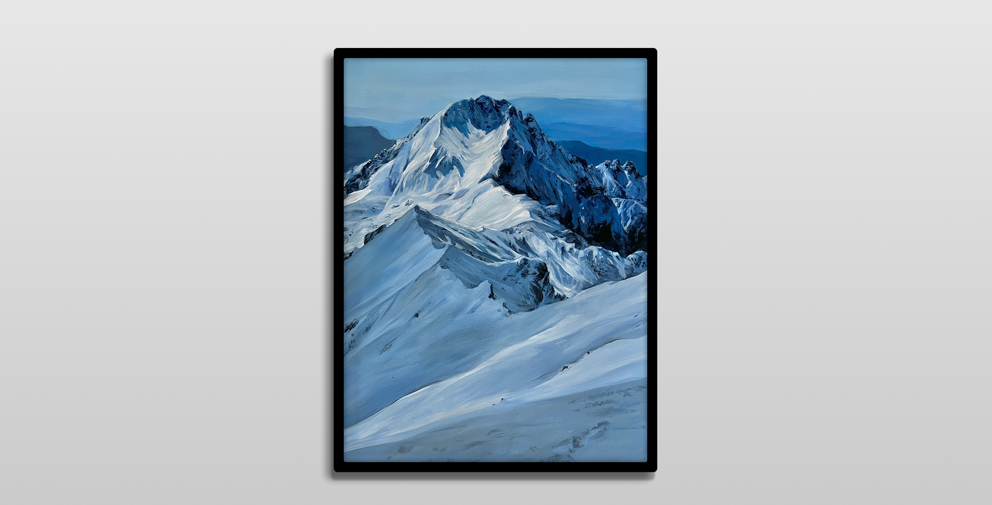 A framed painting on a white wall. 

It is a realistic acrylic landscape painting of a prominent mountain covered in snow. The predominant color is a deep blue.