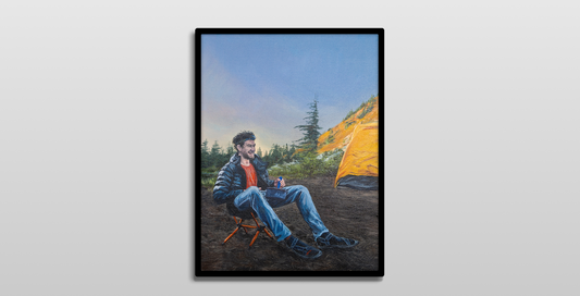 A framed painting hung on a white wall.

It is a realistic painting of a man sitting in a camp chair while eating from a sauce pan. He is smiling, looking to the right. He has brunette curly hair and a short beard and is wearing a puffy black jacket, grey hiking pants, a red shirt, and a headlamp. A yellow tent is in the background, as well as a forest of evergreen trees. The sun is low and casting a golden light on a hill in the distance.