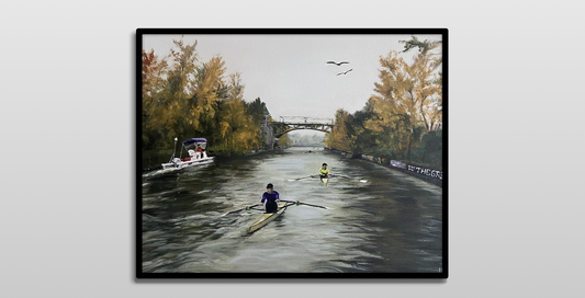 A framed painting on a white wall.

It is an acrylic painting of 2 men in single-person rowing shells rowing down the Montlake Cut in Seattle. There is a coaching launch to the left. In the distance is the Montlake bridge and 3 more distant rowers. The canal is lined with yellow and green fall trees. Two eagles fly overhead. 