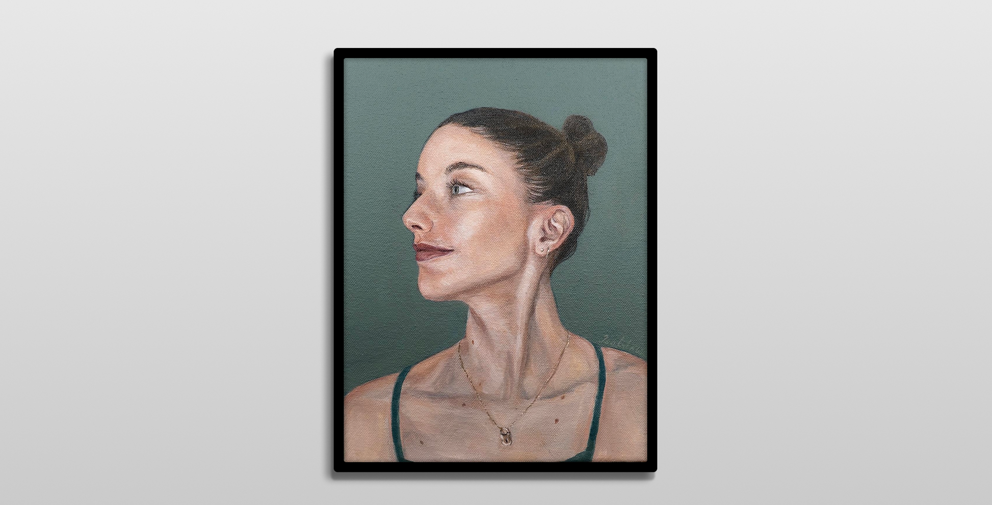 A framed painting hanging on a white wall. 

It is a realistic acrylic portrait of a women looking to her right. She wears her brunette hair in a high bun. The background is a blue-green, matching her eyes.