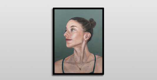 A framed painting hanging on a white wall. 

It is a realistic acrylic portrait of a women looking to her right. She wears her brunette hair in a high bun. The background is a blue-green, matching her eyes.
