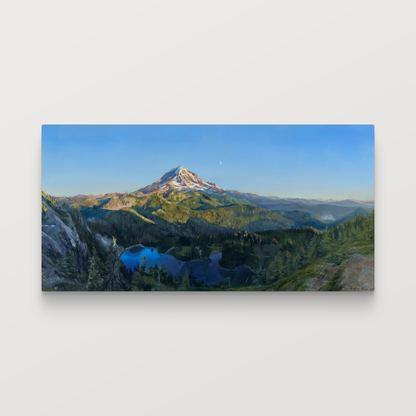 A framed painting hung on a white wall.

The painting is a vibrant realistic landscape of Mount Rainier in the summer. It overlooks Mowich Lake. The sun is setting, casting golden light on the mountain and surrounding hills. The moon can be seen faintly beyond the mountain.
