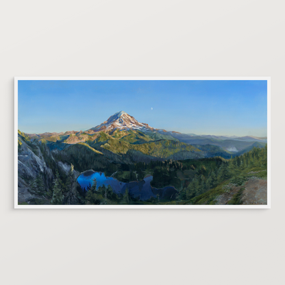 A print of an acrylic painting propped against a white wall.

The painting is a vibrant realistic landscape of Mount Rainier in the summer. It overlooks Mowich Lake. The sun is setting, casting golden light on the mountain and surrounding hills. The moon can be seen faintly beyond the mountain.