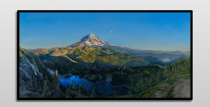 A framed painting hung on a white wall.

The painting is a vibrant realistic landscape of Mount Rainier in the summer. It overlooks Mowich Lake. The sun is setting, casting golden light on the mountain and surrounding hills. The moon can be seen faintly beyond the mountain.