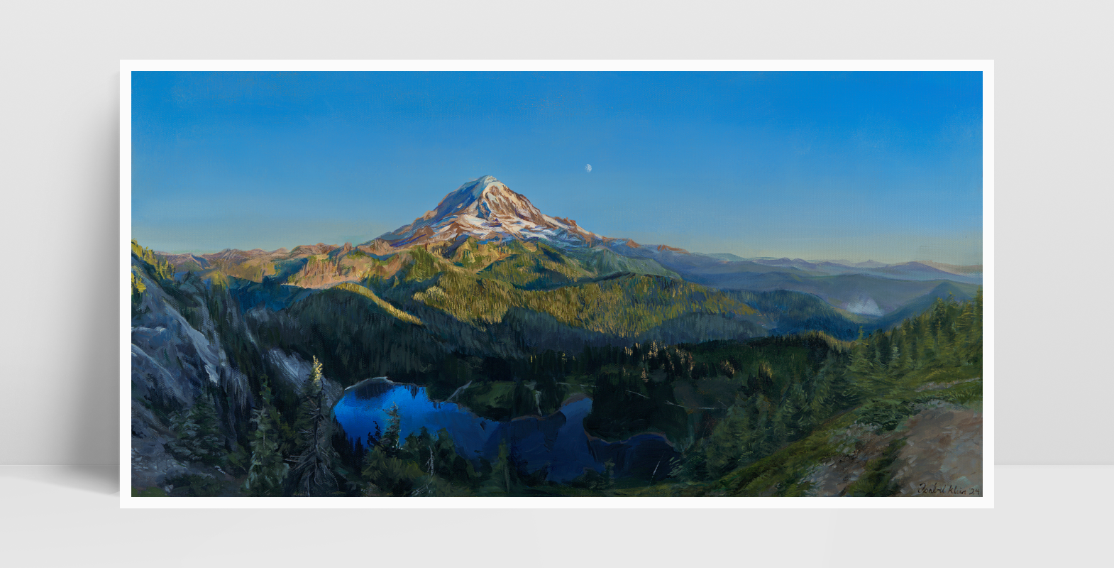 A print of an acrylic painting propped against a white wall.

The painting is a vibrant realistic landscape of Mount Rainier in the summer. It overlooks Mowich Lake. The sun is setting, casting golden light on the mountain and surrounding hills. The moon can be seen faintly beyond the mountain.